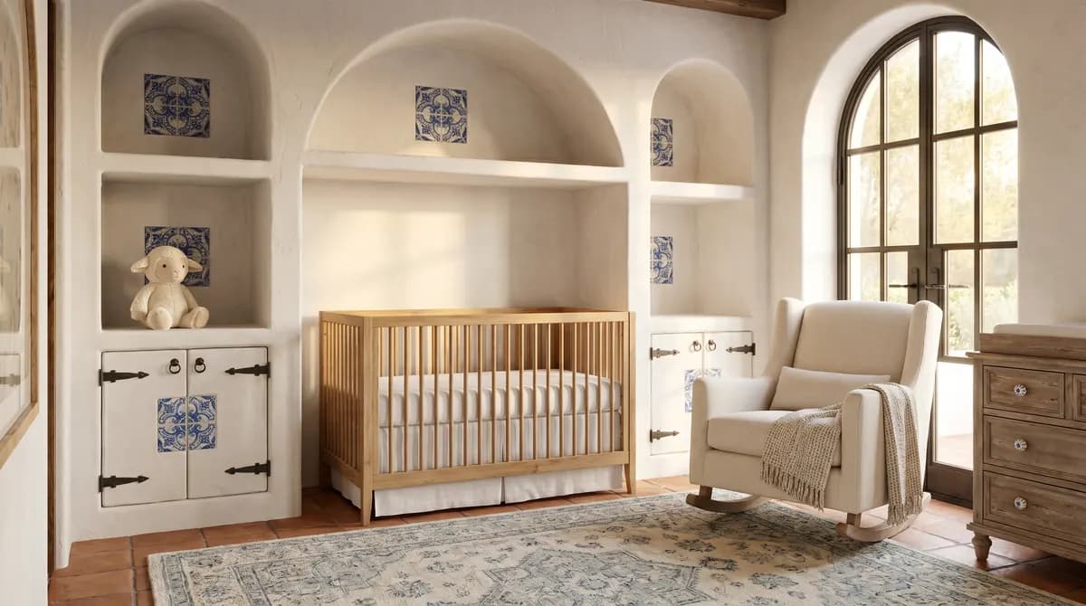 Rustic olive wood crib set against a textured, whitewashed plaster wall.