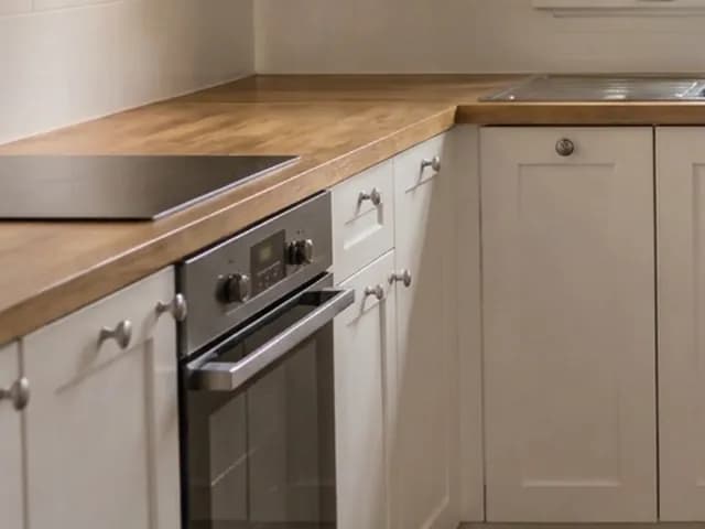 A real kitchen run: the counters are clear, but the gas hob came back as a plain glass cooktop. — After Remove clutter